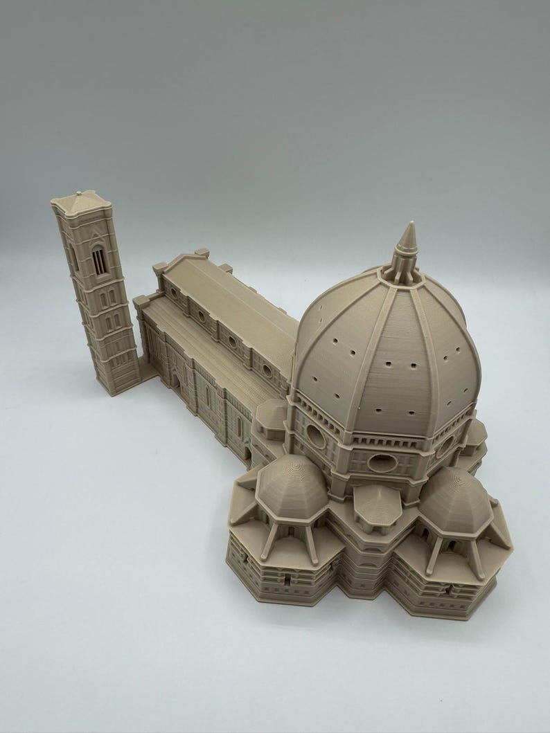 May include: A beige 3D-printed model of the Florence Cathedral, featuring the iconic dome, bell tower, and architectural details. The model showcases the building's intricate design and structure.
