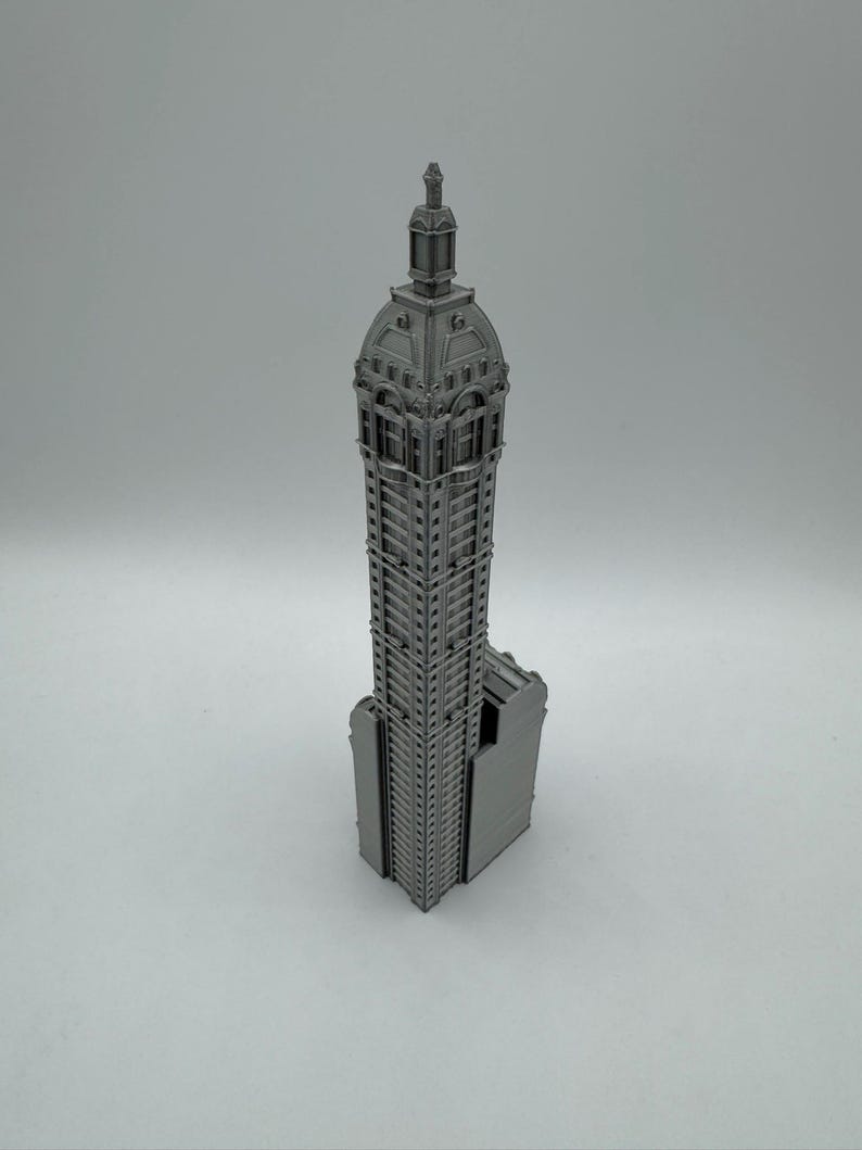 May include: A gray 3D printed model of a tall building with a domed roof and intricate details.