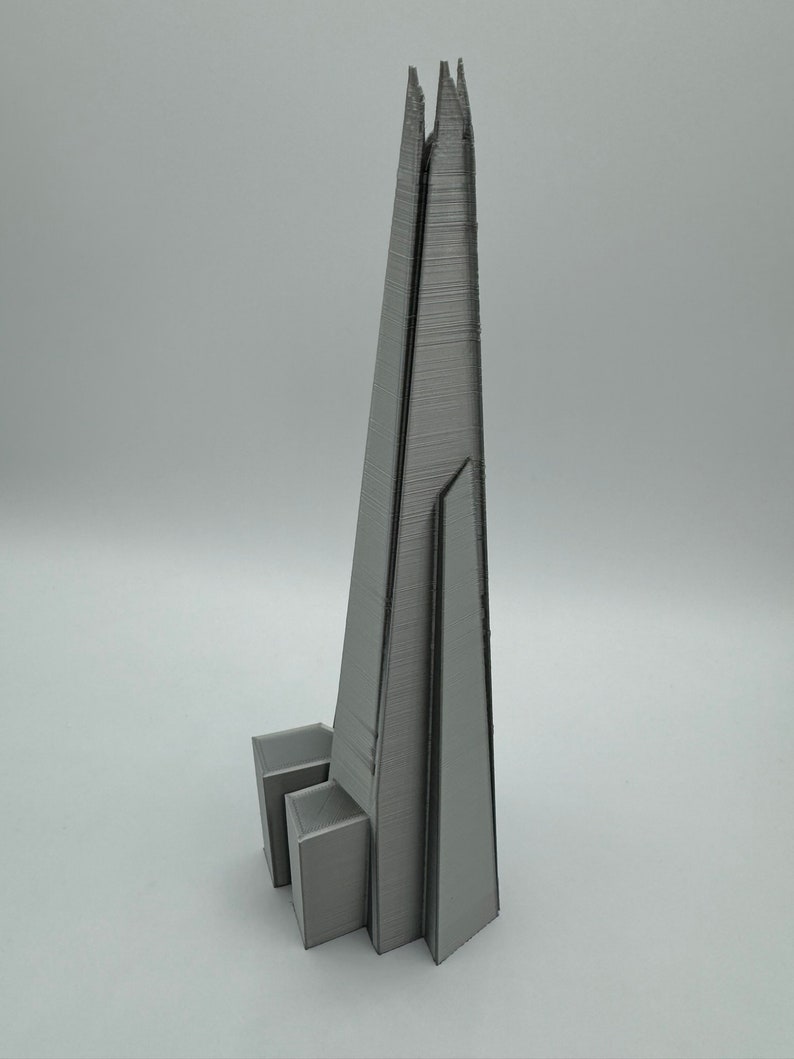 May include: A gray 3D printed model of the Shard, a skyscraper in London, England.