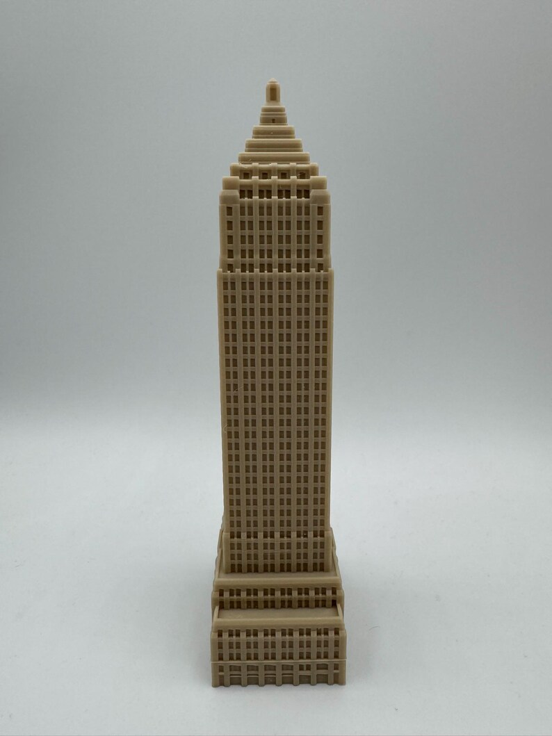 Puede incluir: Un modelo en miniatura beige de un rascacielos con un techo puntiagudo y muchas ventanas.