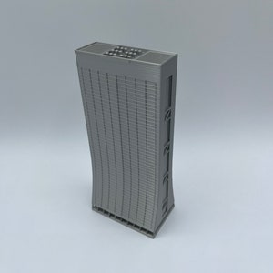 May include: A gray 3D printed model of a tall, modern skyscraper with a curved facade and a flat roof.