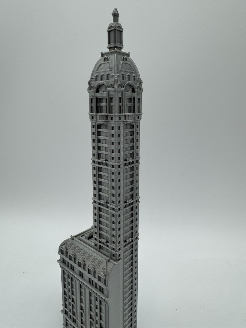 May include: A gray 3D printed model of a tall, ornate building with a domed roof.