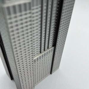 Peut inclure: Mod&egrave;le argent&eacute; d'un gratte-ciel avec une surface textur&eacute;e. Le mod&egrave;le est en m&eacute;tal et a une forme rectangulaire.