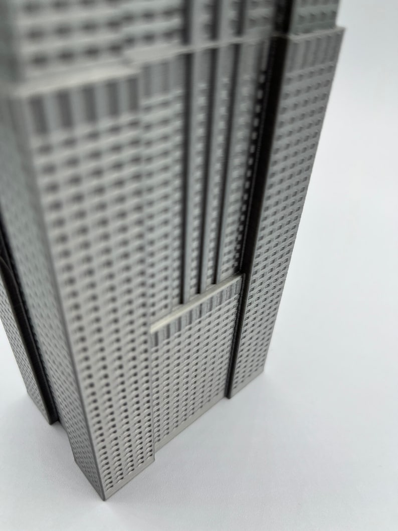 Peut inclure: Mod&egrave;le argent&eacute; d'un gratte-ciel avec une surface textur&eacute;e. Le mod&egrave;le est en m&eacute;tal et a une forme rectangulaire.