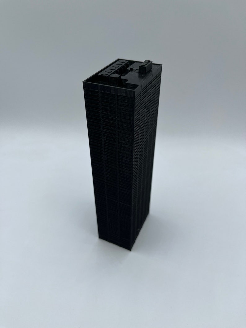 May include: A black 3D printed model of a skyscraper.