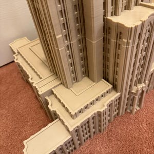 Puede incluir: Un modelo detallado de un edificio alto con m&uacute;ltiples niveles y detalles arquitect&oacute;nicos intrincados. El modelo est&aacute; hecho de un material marr&oacute;n claro y parece estar hecho de pl&aacute;stico o resina.