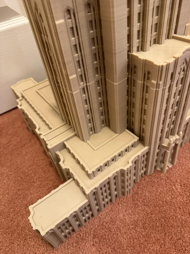 Puede incluir: Un modelo detallado de un edificio alto con m&uacute;ltiples niveles y detalles arquitect&oacute;nicos intrincados. El modelo est&aacute; hecho de un material marr&oacute;n claro y parece estar hecho de pl&aacute;stico o resina.