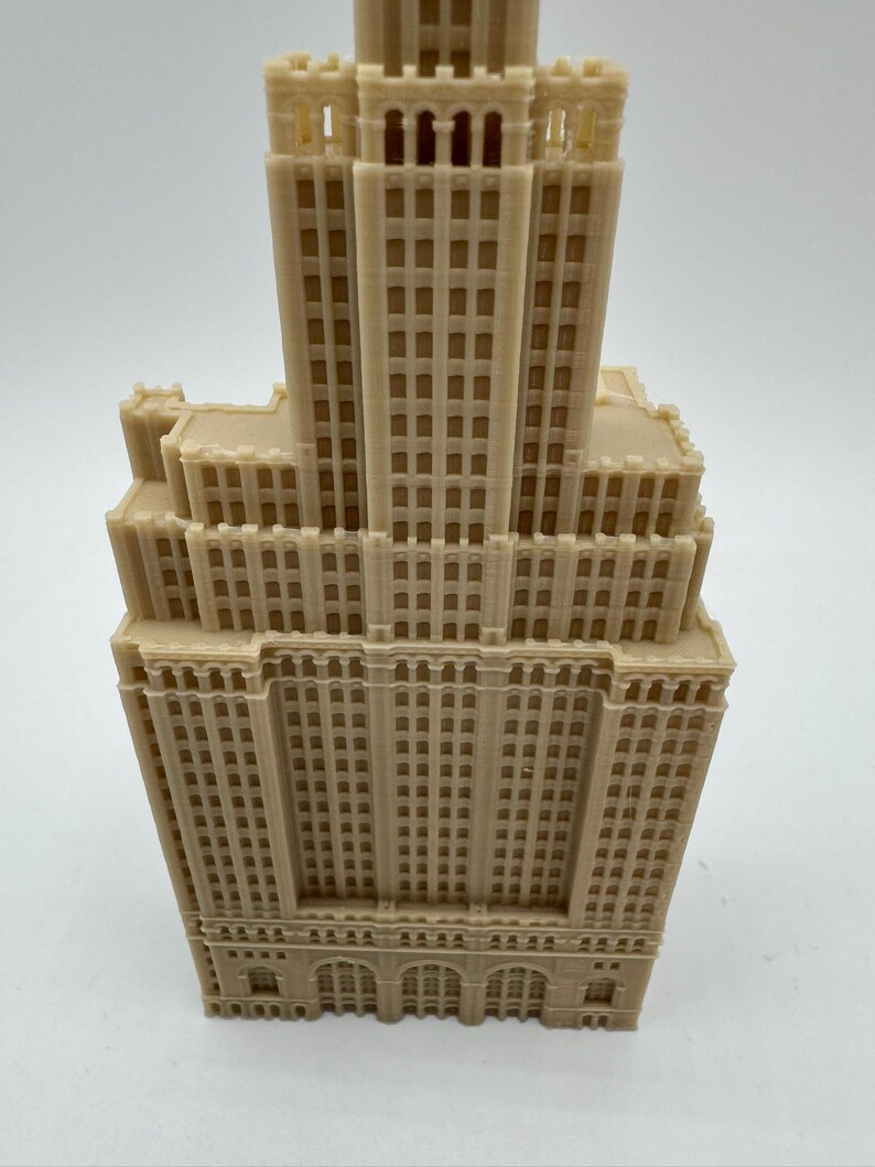 May include: A detailed 3D printed model of a tall, beige building with many windows. The building has a flat roof and a decorative cornice.