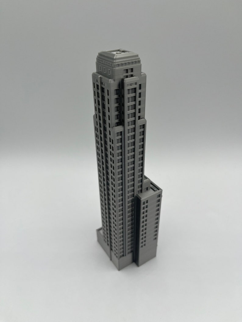 May include: A gray 3D printed model of a tall skyscraper with a rectangular base and a flat roof.