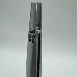 May include: A pair of silver-colored metal tweezers with a textured surface and a pointed tip.