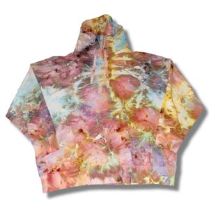 May include: A tie-dye hoodie in a blend of colors including pink, yellow, blue, and white. The hooded sweatshirt has a drawstring and a kangaroo pocket. The fabric has a unique, artistic pattern, making it a standout piece of apparel.