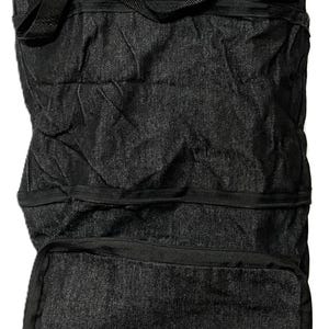 May include: Black rolling tote bag with a purple accent. The bag has a telescoping handle and wheels for easy transport. The front of the bag features three white graphic designs. A practical and stylish travel accessory.