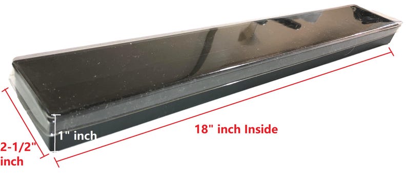 Op de afbeelding: Een zwarte rechthoekige container met een doorzichtig deksel. De binnenafmetingen zijn 45,7 cm lang, 2,5 cm diep en 6,4 cm breed. De container is ontworpen om items in te bewaren.