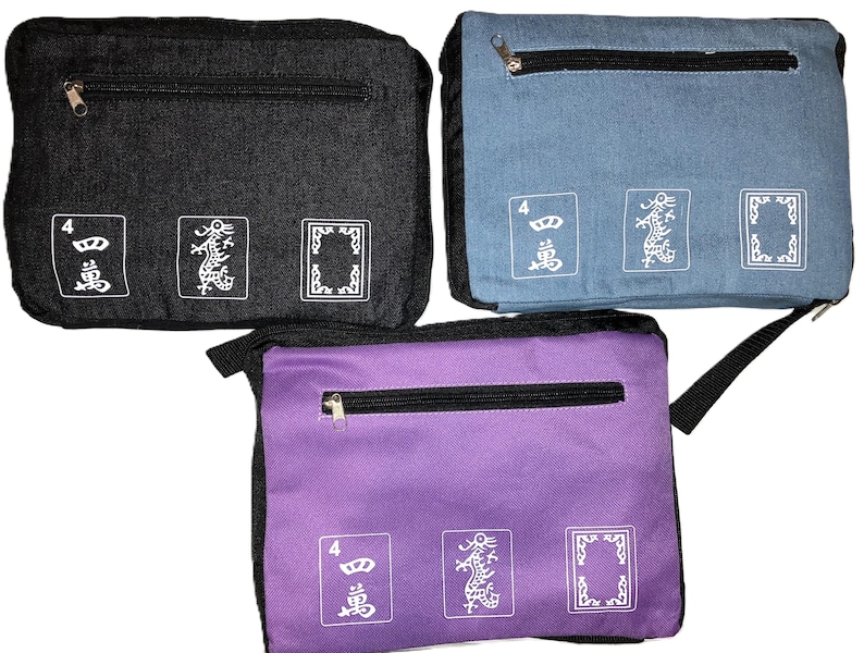 May include: Three rectangular fabric bags in black, blue, and purple. Each bag has a zippered top pocket and three white graphic designs on the front. The designs include the number 4, a dragon, and a framed shape. The bags have black straps.