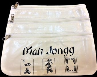 May include: Off-white Mah Jongg bag with three zippered compartments. The bag features the words "Mah Jongg" in black script, along with three illustrated game tiles. The bag is rectangular and has a glossy finish.