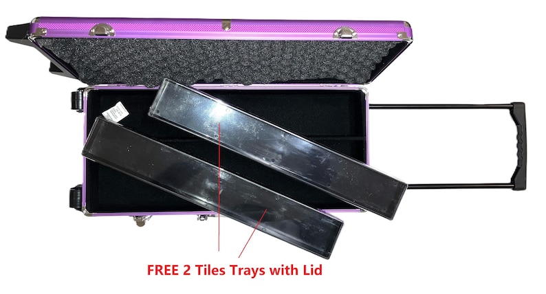 May include: A purple rolling makeup case with a black handle and two black trays. The case is open, revealing a black interior and foam padding. The text "FREE 2 Tiles Trays with Lid" is visible.