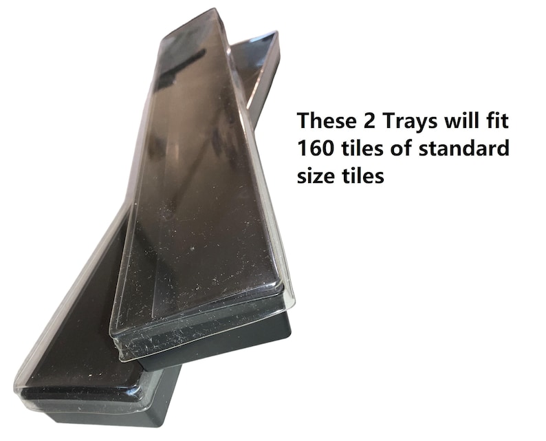 Op de afbeelding: Twee zwarte rechthoekige trays met doorzichtige plastic deksels zijn onder een hoek gestapeld. De tekst op de afbeelding geeft aan dat de twee trays 160 tegels van standaardformaat zullen bevatten. De trays lijken leeg te zijn.