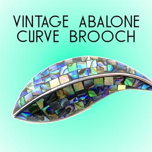 May include: Vintage abalone curve brooch, featuring a mosaic of iridescent blue, green, and gold abalone shell pieces set in silver. The brooch is shaped like a leaf and has a curved design.