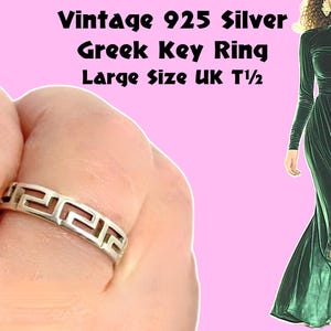 Può includere: Un anello vintage in argento 925 con motivo a chiave greca. L'anello presenta un motivo geometrico ripetuto. L'anello è di taglia grande, UK T 1/2. L'anello è mostrato su una mano su sfondo rosa. Il testo "Vintage 925 Silver Greek Key Ring Large Size UK T 1/2" è in alto.