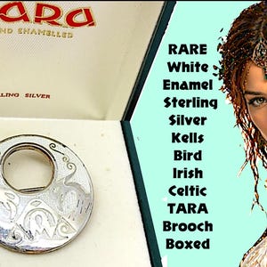 May include: A circular sterling silver brooch featuring white enamel and engraved bird motifs, presented in a branded box labeled Tara Hand Enamelled Sterling Silver. The brooch displays intricate Celtic-inspired patterns on its metallic surface.