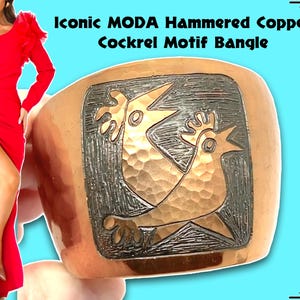 Könnte beinhalten: Ein gehämmertes Kupferarmband mit einem Hahn-Motiv. Das Armband ist dunkelkupferfarben mit einer gehämmerten Textur. Das Hahn-Motiv ist silberfarben und erhebt sich von der Oberfläche des Armbands.