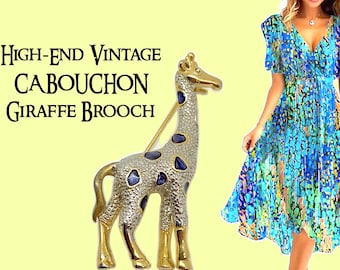 Könnte beinhalten: Eine goldfarbene Giraffenbrosche mit blauen Cabochon-Akzenten. Die Giraffe steht auf allen vieren mit erhobenem Kopf. Die Brosche ist ein hochwertiges Vintage-Stück.