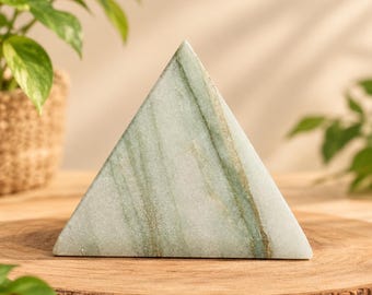 May include: A pyramid-shaped stone object with a smooth, polished surface. The stone features a pale white base color with prominent, flowing veins of sage green and darker forest green running diagonally across its triangular faces.