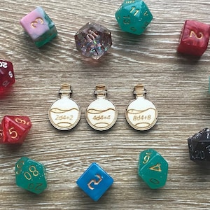May include: A collection of dice and potion bottles with various numbers and symbols. The dice are in different colors, including red, green, blue, and pink. The potion bottles are made of wood and have a white background with black text. The text on the bottles reads "2d4+2", "4d4+4", and "8d4+8".