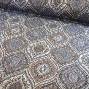 Könnte beinhalten: Ein Stoff mit einem sich wiederholenden Muster aus braunen, blauen und weißen paisleyartigen Designs. Der Stoff hat eine strukturierte, gewebte Optik.