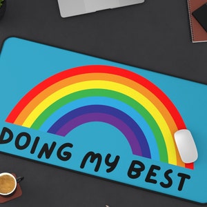 May include: A blue desk mat with a rainbow design and the text "Doing My Best".