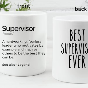 Op de afbeelding: Witte keramische koffiemok met een zwart ontwerp. De voorkant van de mok heeft de definitie van het woord "Supervisor" en de achterkant van de mok zegt "Beste Supervisor ooit".