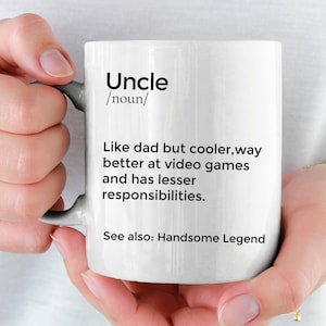 Puede incluir: Taza de cerámica blanca con un diseño negro que dice "Tío /sustantivo/ Como papá pero más cool, mucho mejor en los videojuegos y tiene menos responsabilidades. Ver también: Leyenda apuesto"