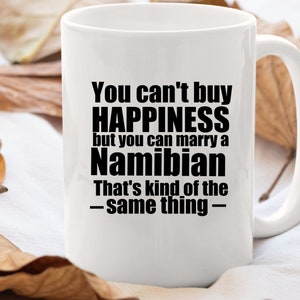 Puede incluir: Taza de cerámica blanca con un diseño de texto negro que dice "You can't buy HAPPINESS but you can marry a Namibian That's kind of the -same thing- "