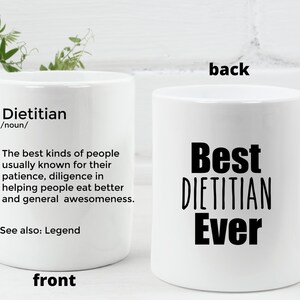 May include: White ceramic mug with a black design. The front of the mug has the definition of the word "Dietitian" and the back of the mug says "Best Dietitian Ever".