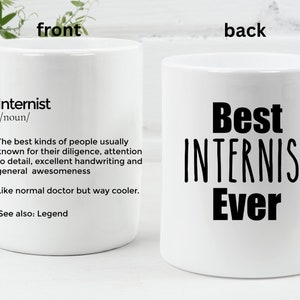 May include: White ceramic coffee mug with a black design. The front of the mug has the definition of the word "Internist" and the back of the mug says "Best Internist Ever".
