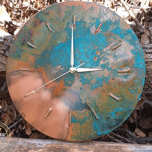 Rustic Handmade Old Copper Wall Clock with Silver Colored Hands on a natural wooden background under natural sunlight by Copper Empire