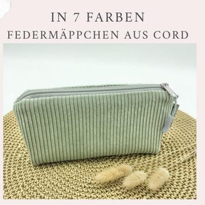 Könnte beinhalten: Ein mintgrünes Stiftemäppchen aus Cord mit einem silbernen Reißverschluss. Das Federmäppchen ist rechteckig und hat vertikale Rippendetails. Der Text "IN 7 FARBEN FEDERMÄPPCHEN AUS CORD" befindet sich oben im Bild.