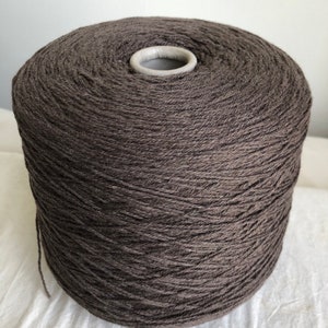 May include: A large spool of dark brown yarn.