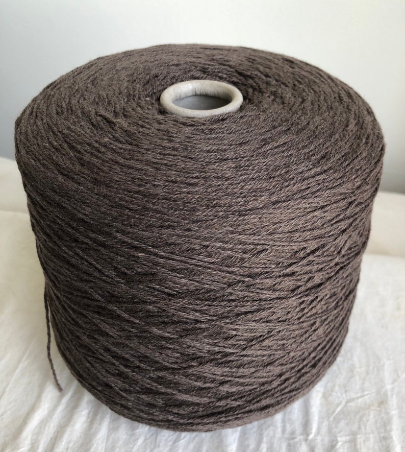 May include: A large spool of dark brown yarn.
