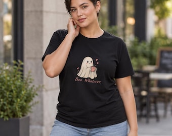 Puede incluir: Una camiseta negra de manga corta con un gráfico de un fantasma blanco sosteniendo una taza rosa, rodeado de pequeños corazones rosas. Debajo del fantasma, el texto "Boo. Whatever." aparece en una fuente sencilla de color rojo oscuro. La camiseta tiene cuello redondo.