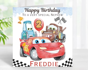 May include: A birthday card featuring a red race car, a blue car, and a rusty brown tow truck. The card has a blue background with white clouds and the text "Happy Birthday to a Very Special Nephew". The number "2" is in a red balloon. The card is signed "Freddie".