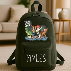 May include: A dark green backpack with a colourful graphic of Toy Story characters. The backpack has a front pocket with the name "MYLES" in white script. It features a top handle and adjustable shoulder straps.