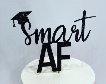 May include: Black glitter graduation cap cake topper with the text "Smart AF".