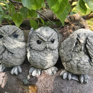 Könnte beinhalten: Drei graue Steinhühnchen-Figuren, jede mit einer anderen Handgeste, die "Sehe kein Übel, höre kein Übel, sprich kein Übel" darstellt.