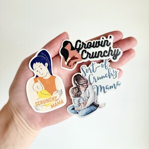 May include: Four colorful stickers featuring illustrations of mothers and children with text that reads "Growin' Crunchy", "Sort-of Crunchy Mama", and "Scrunchy Mama".
