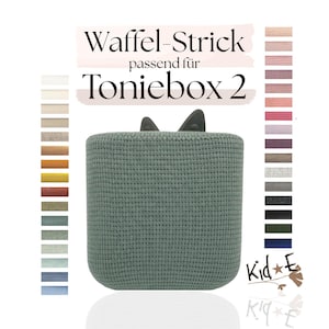 Könnte beinhalten: Ein grüner, strukturierter Aufbewahrungsbehälter mit zwei kleinen, dunkelgrauen Ohren oben. Der Behälter ist mit "Waffel-Strick passend für Toniebox 2" beschriftet. Eine Farbpalette verschiedener Farbtöne wird angezeigt.