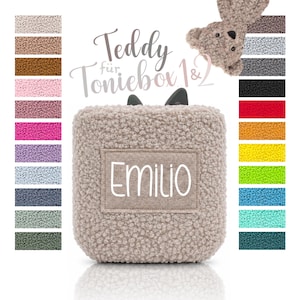 Könnte beinhalten: Ein beigefarbener Teddybär-Bezug für eine Toniebox mit einer strukturierten, lockigen Stoffoberfläche und einem rechteckigen Aufnäher, auf dem der Name Emilio in Weiß gedruckt ist. Das Bild enthält eine Farbpalette mit verschiedenen Stoffmustern.