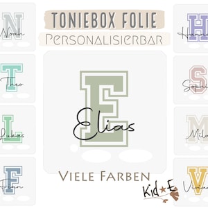 Könnte beinhalten: Ein Set personalisierbarer Bügelbilder aus Vinyl für Toniebox-Lautsprecher. Die Aufkleber zeigen verschiedene Buchstaben und Namen, darunter Noah, Theo, Lukas, Elias, Hannah, Sophia, Mila, Finn und Vivian. Die Aufkleber sind in verschiedenen Farben erhältlich. Der Text "TONIEBOX FOLIE PERSONALISIERBAR VIELE FARBEN Kid*E" ist ebenfalls auf dem Bild zu sehen.