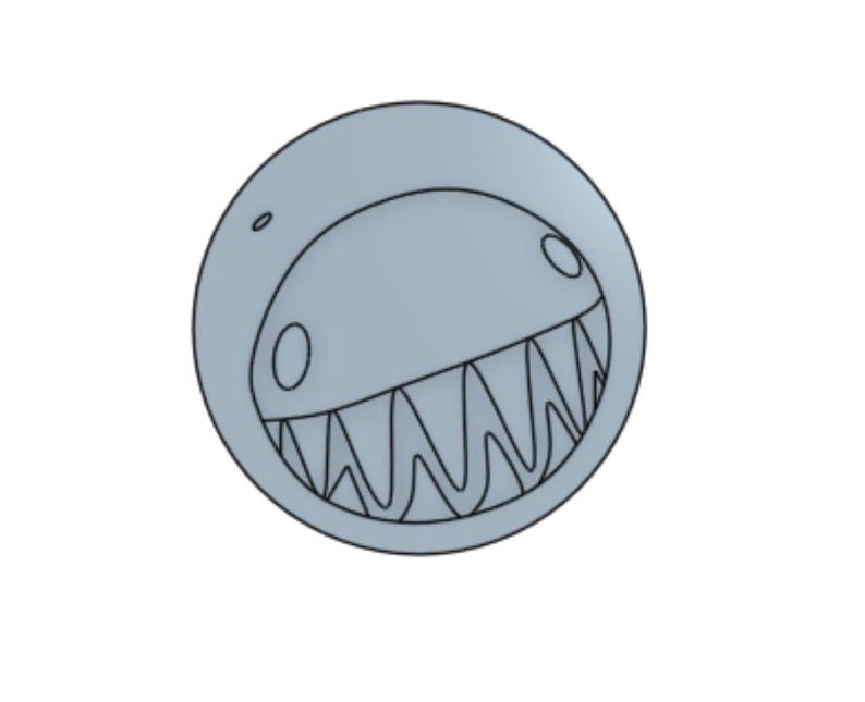 May include: A light gray, circular design featuring a stylized, toothy grin. The design has a cartoonish aesthetic, with a curved upper edge and a detailed outline of the mouth and teeth. The overall shape is a perfect circle.