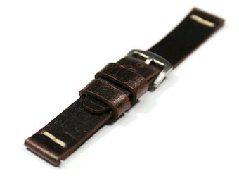May include: A dark brown leather watch strap with a silver-colored buckle. The strap has a distressed texture and off-white stitching near the ends. The watch band is designed to be durable and stylish.